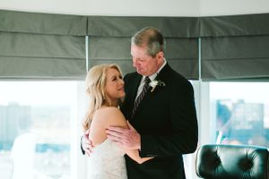Intimate dance moment between bride and older gentleman during wedding reception.