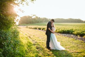 Sunset wedding portrait in a golden field during magic hour.