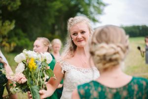 A wedding party gathering outdoors with colorful bouquets and formal attire.