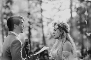 A couple exchanges vows during an intimate forest wedding ceremony.