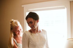 Two people share a joyful moment while getting ready for a wedding.