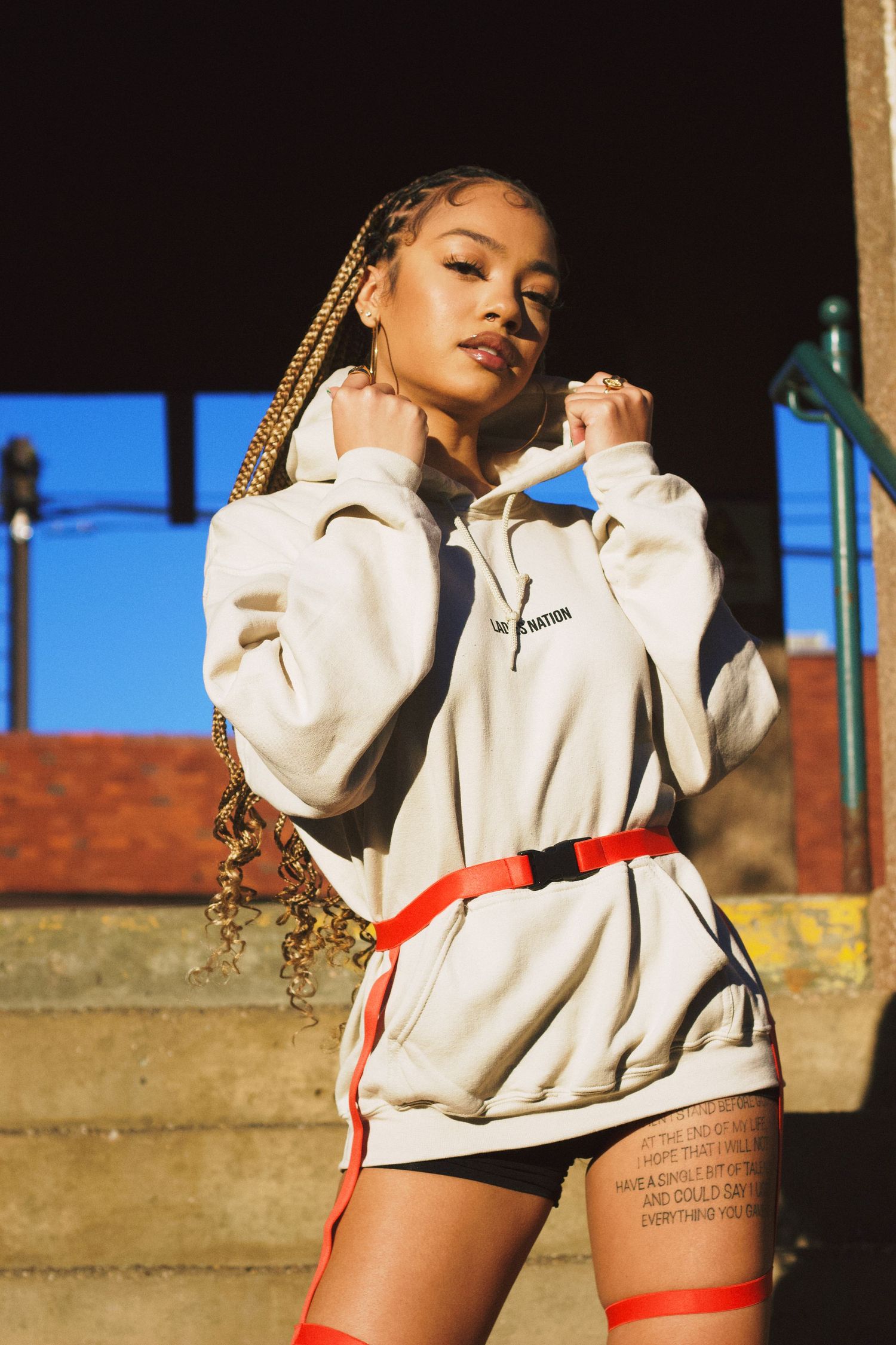 Front view of singer/songwriter Juani modeling new fashion hoody for streetwear brand Ladies Nation.