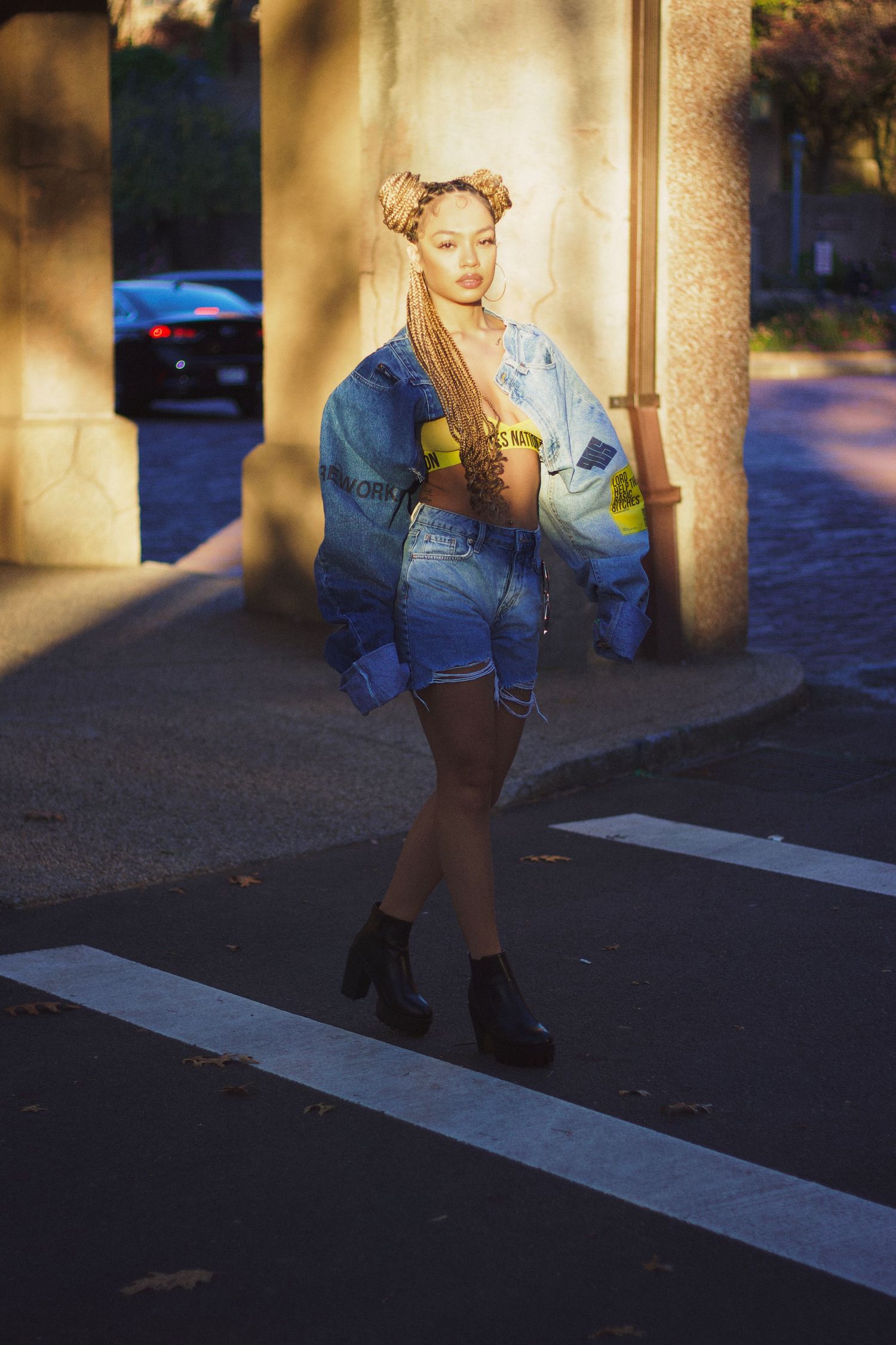 Singer/songwriter Juani crossing street in fashion denim top and bottom for streetwear brand Ladies Nation.