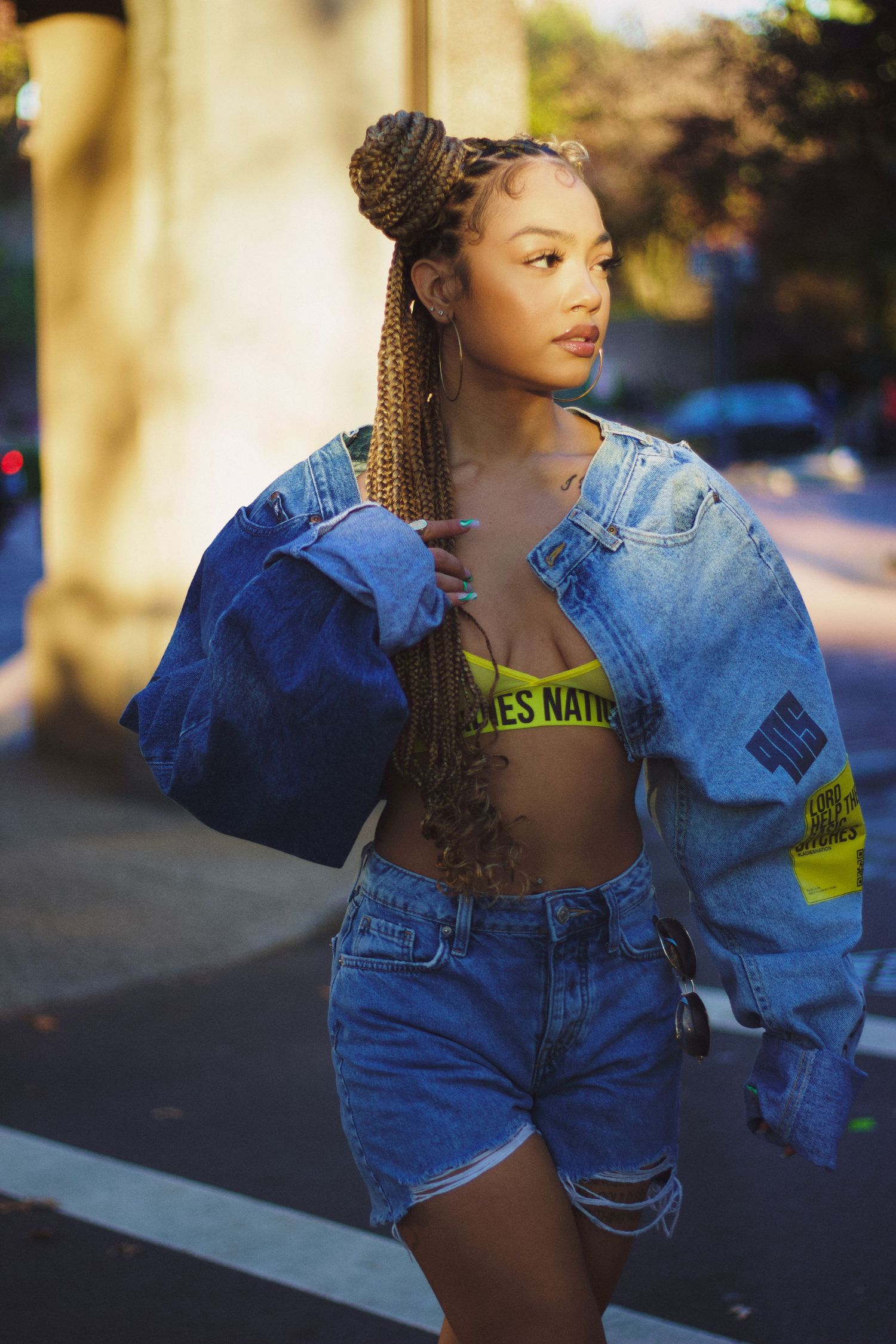 Singer/songwriter Juani crossing street in fashion denim top and bottom for streetwear brand Ladies Nation.