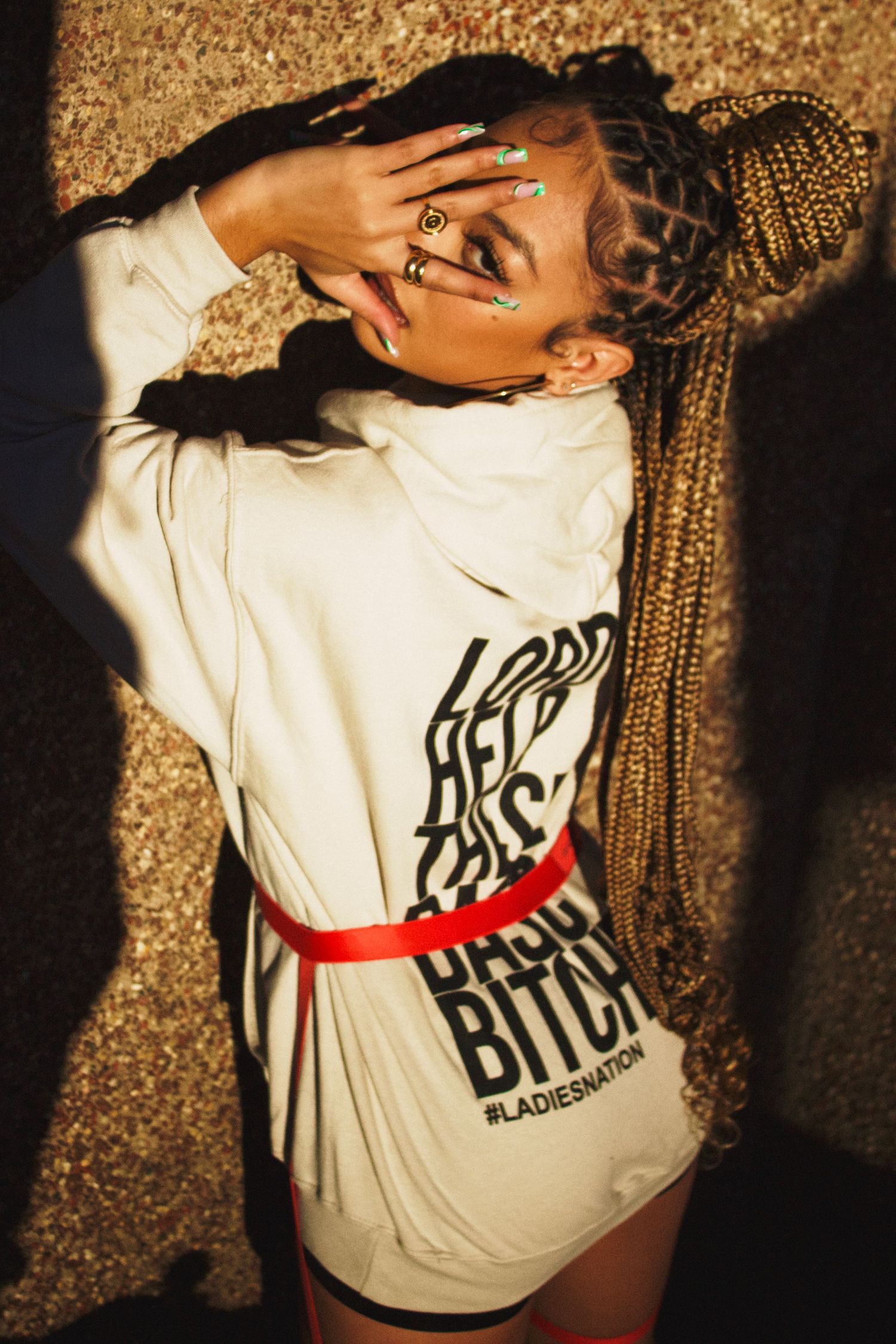 Back view of singer/songwriter Juani modeling new fashion hoody for streetwear brand Ladies Nation.