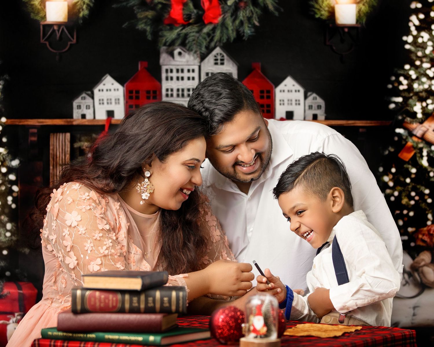 Family sharing holiday moments decorating Christmas ornaments together at a table with miniature houses.