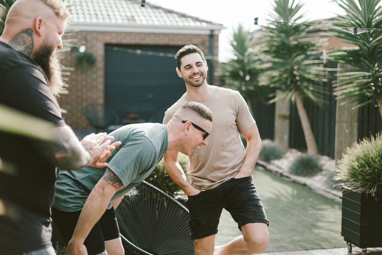 Group enjoying playful moment in backyard garden setting.