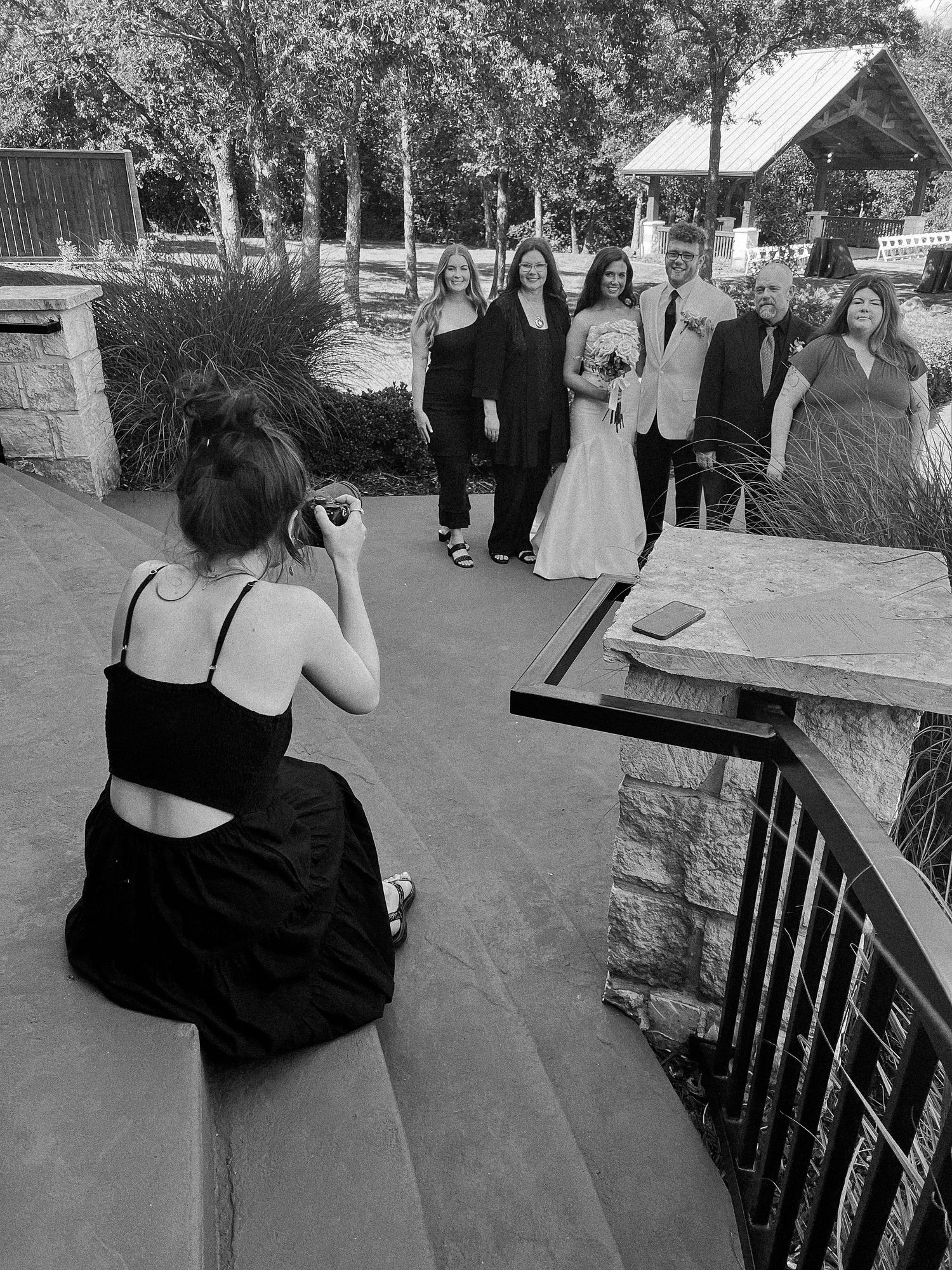 Wedding guests gather on an outdoor terrace during a reception.