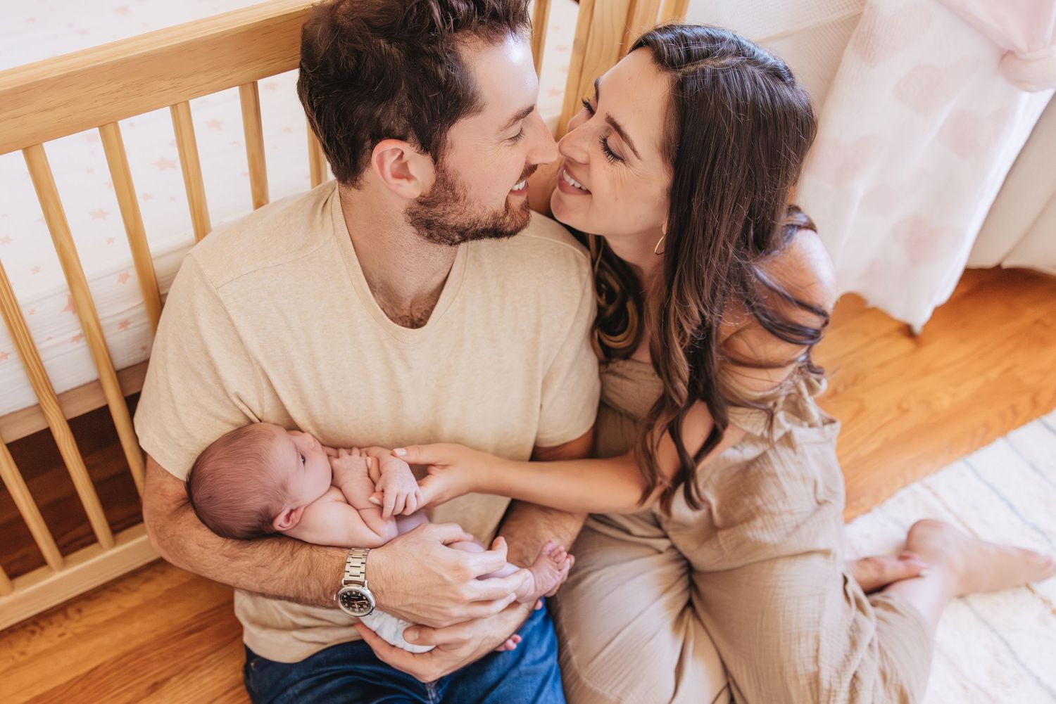 Intimate family moment captured in natural light on wooden furniture.