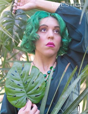 Artistic portrait with monstera leaves and vibrant green styling elements.