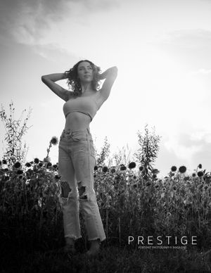 A dreamy black and white portrait of a woman posing in a field of wildflowers.
