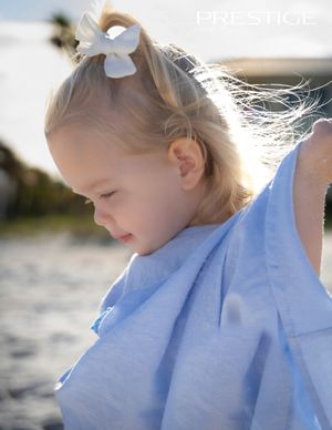 Ethereal beach portrait series with soft lighting and pale blue dress.
