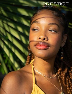 Fashion portrait featuring yellow top, jewelry and natural palm frond backdrop.