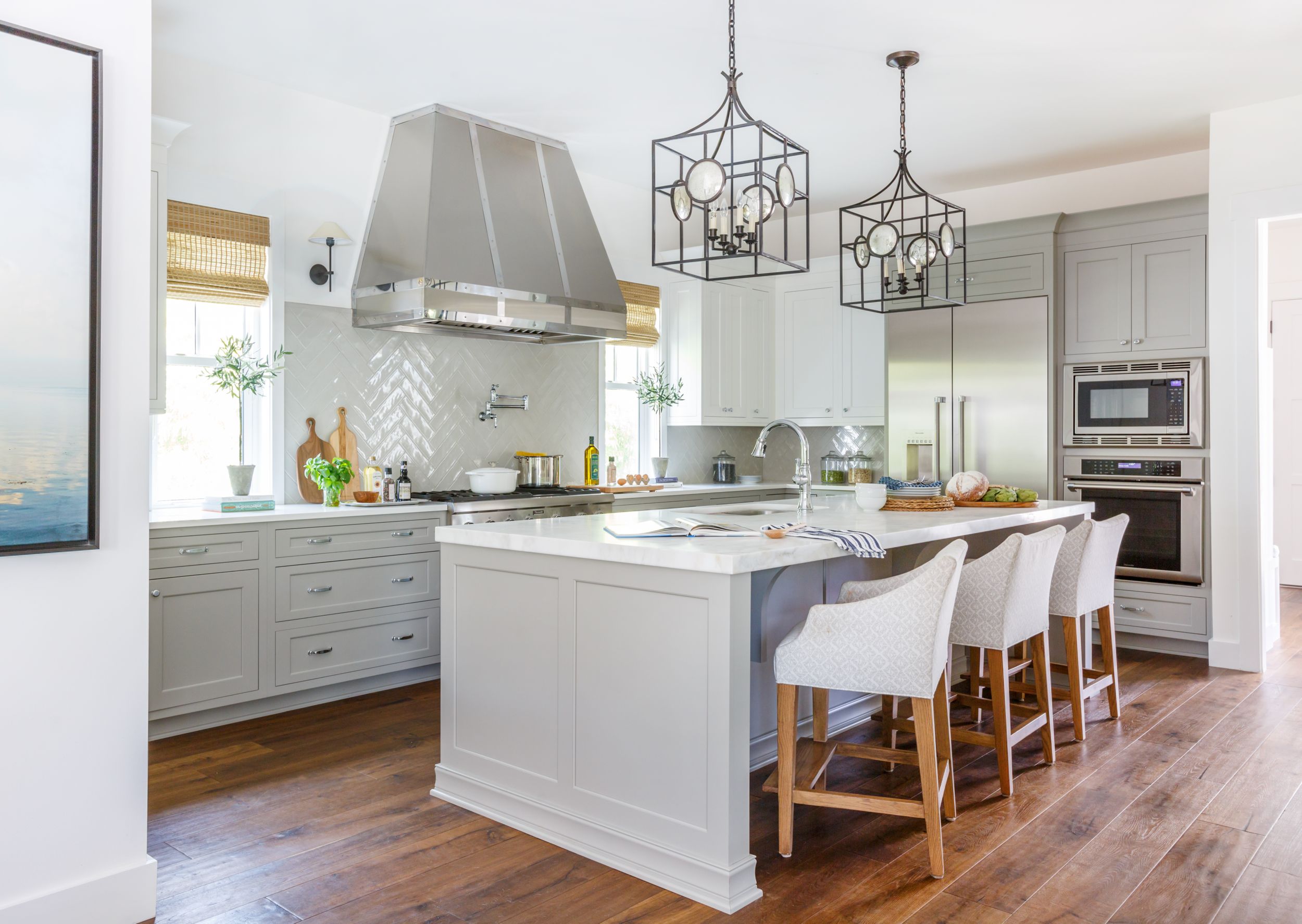 Visual comfort pendants hanging above Calcutta gold island.