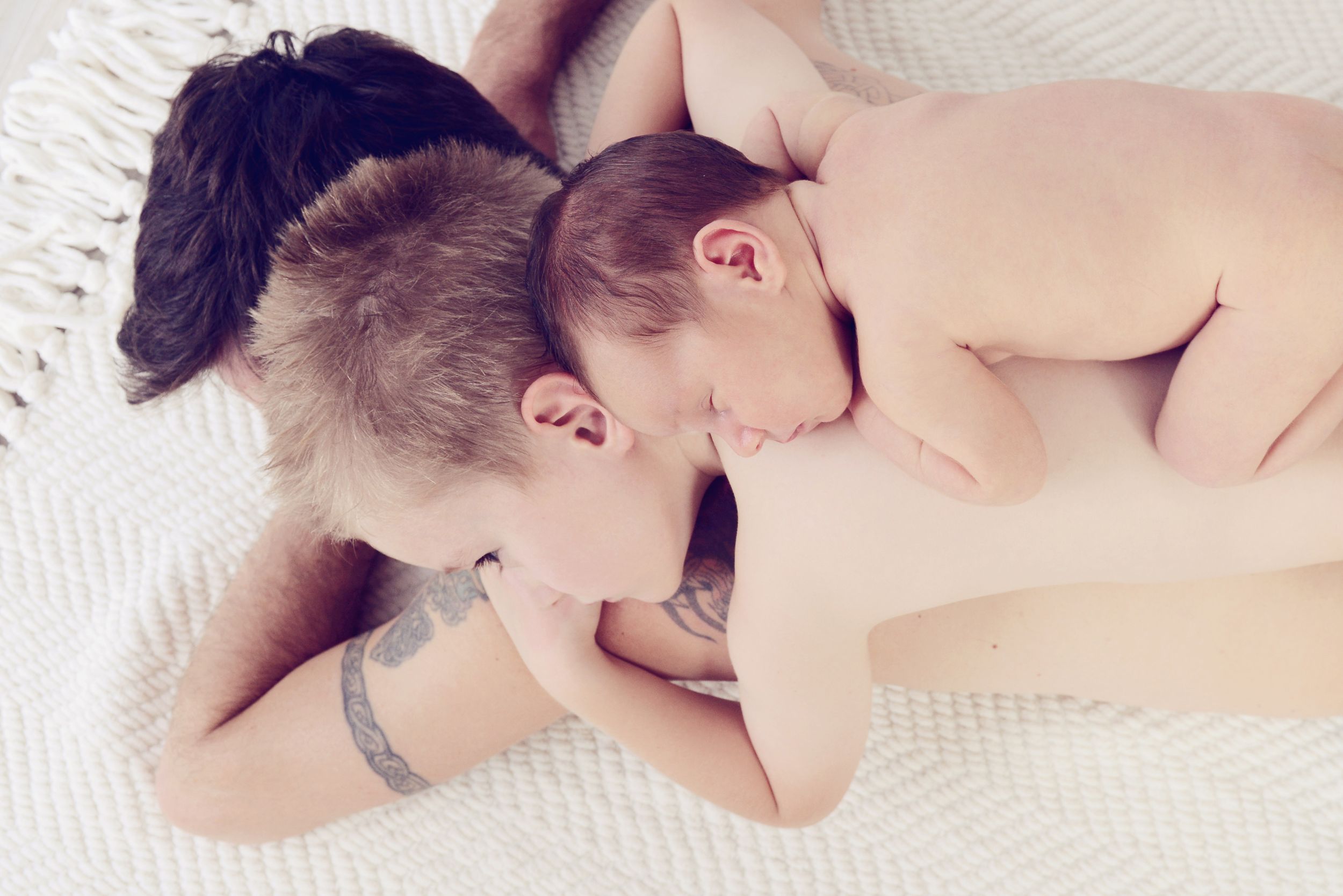Dad with son and newborn laying in a stack