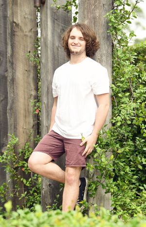 Young man leans against timber frame