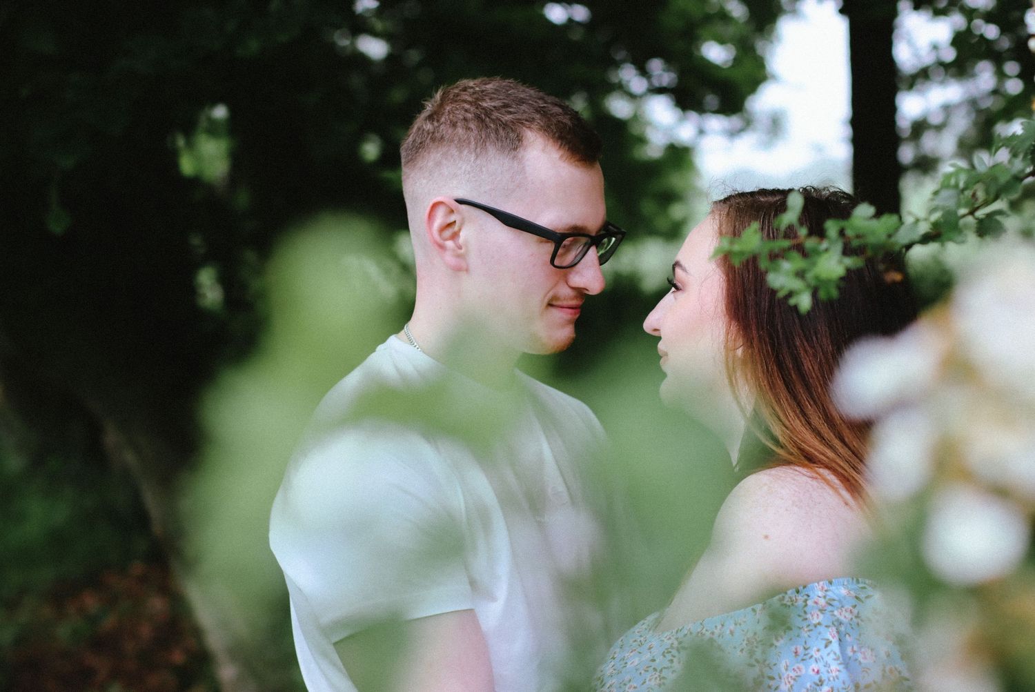 Romantic couple sharing an intimate moment in a dreamy garden setting.