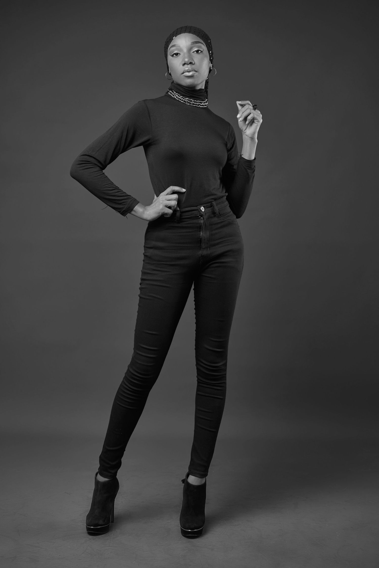 Dramatic black and white fashion poses featuring all-black outfit against dark backdrop.