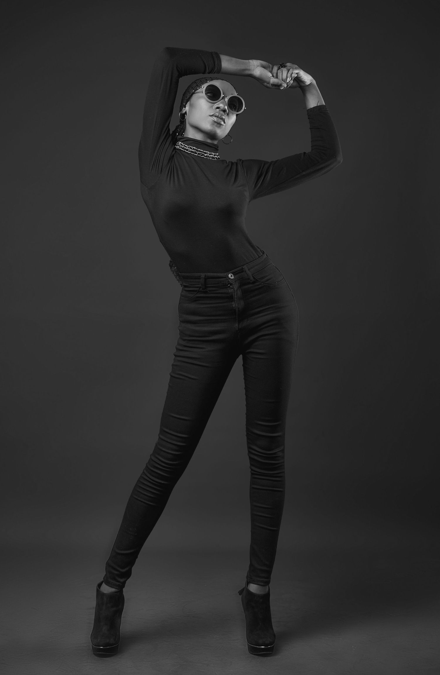Black and white studio fashion poses showcasing fitted dark ensemble.