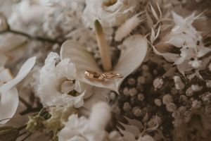 Close-up of wedding rings nestled among delicate white flowers and baby's breath.