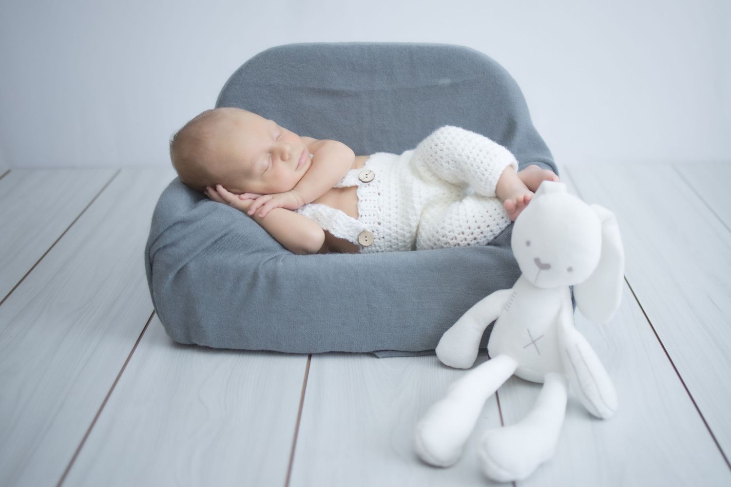 Sleeping newborn baby on miniature sofa during studio newborn session in Centurion with soft, timeless styling and neutral tones