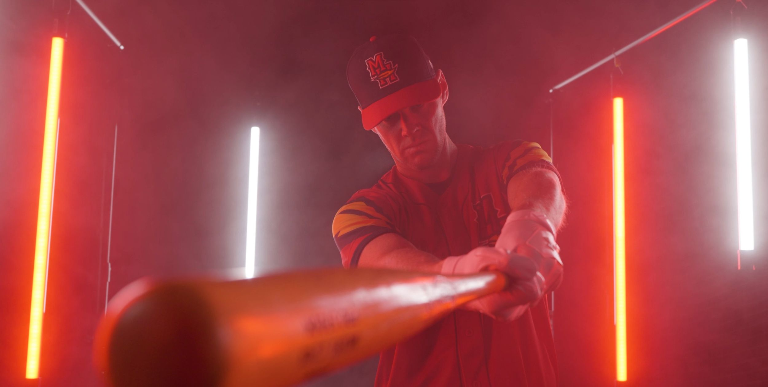 Action shot with dramatic red and white neon lighting bars in dark environment.