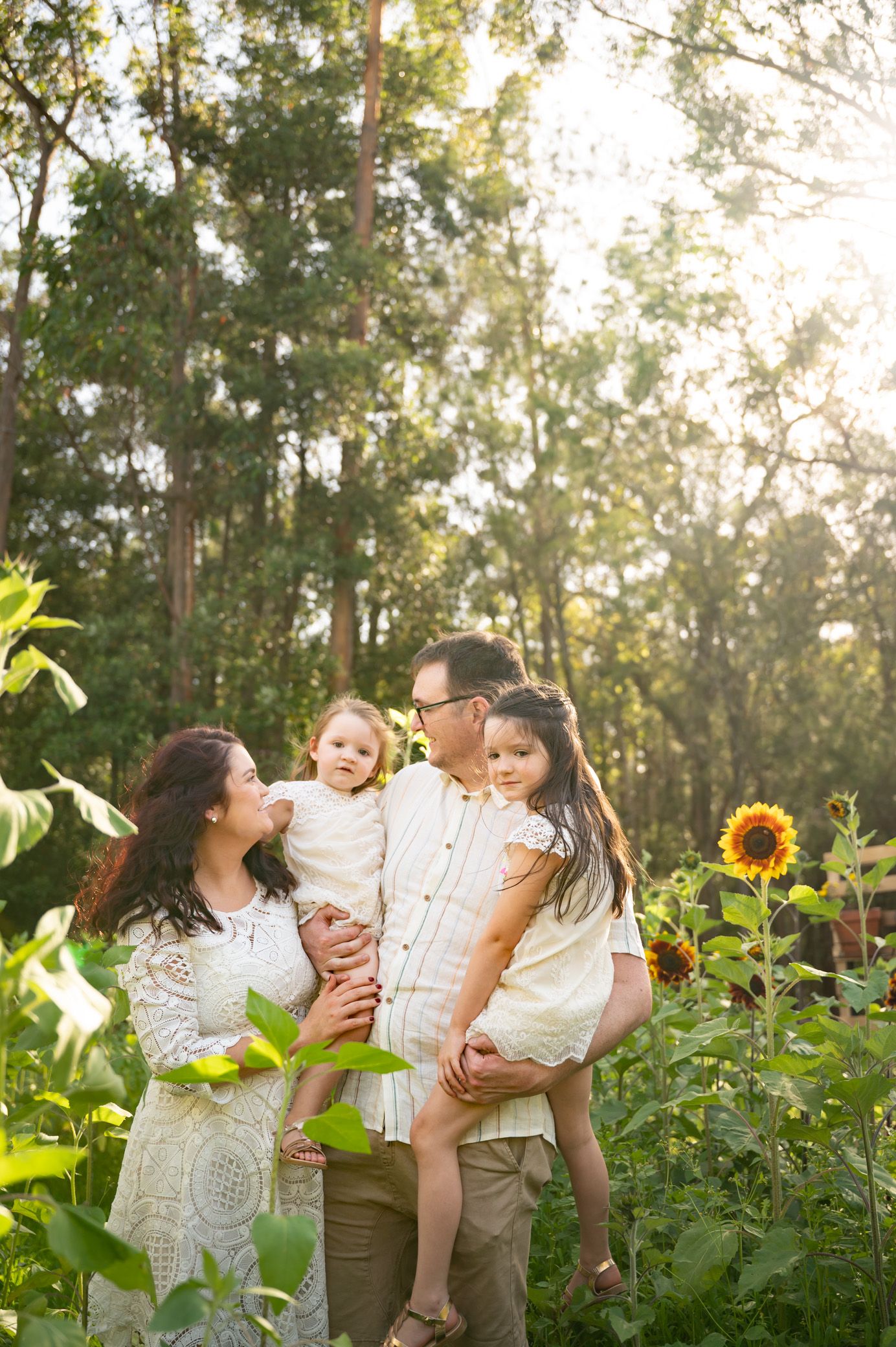 Happy family standing in sunflower field