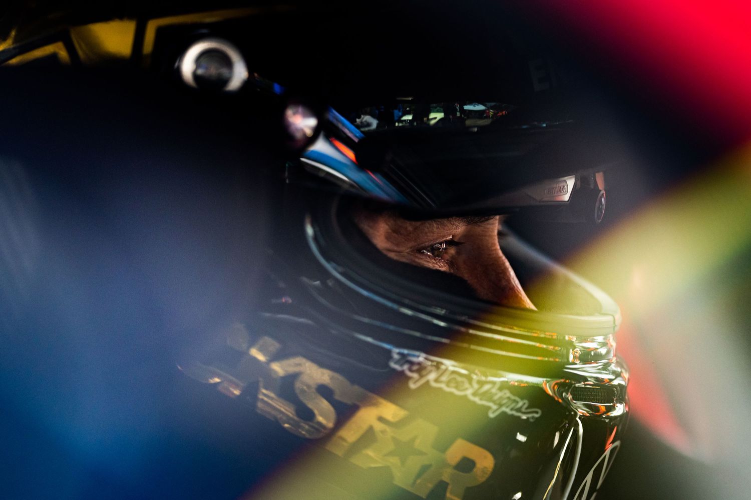 Close-up abstract shot of racing car details with dramatic lighting and reflections.