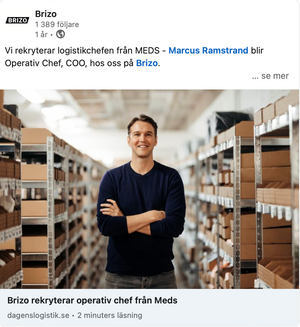Operations manager standing confidently in warehouse aisle surrounded by shelving units.