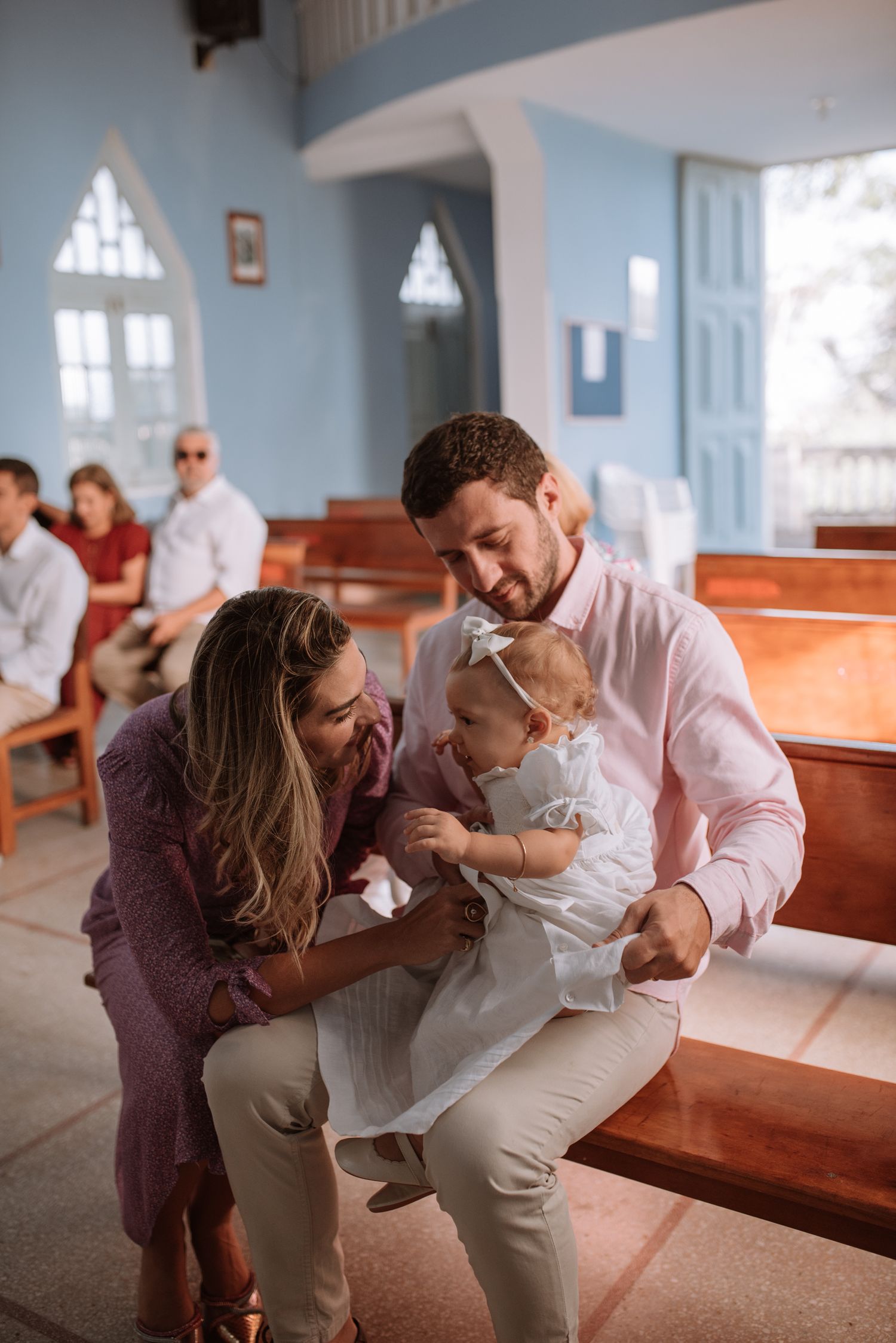 A joyful family moment inside a church with blue walls and wooden pews.
