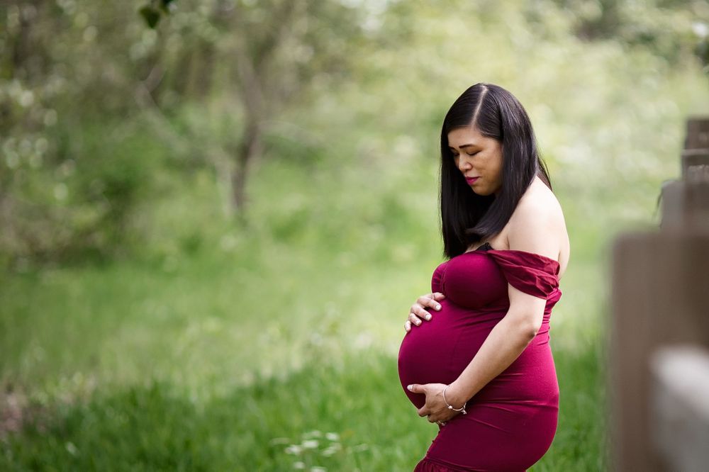 Stunning mom in a beautiful burgundy maternity gown.
