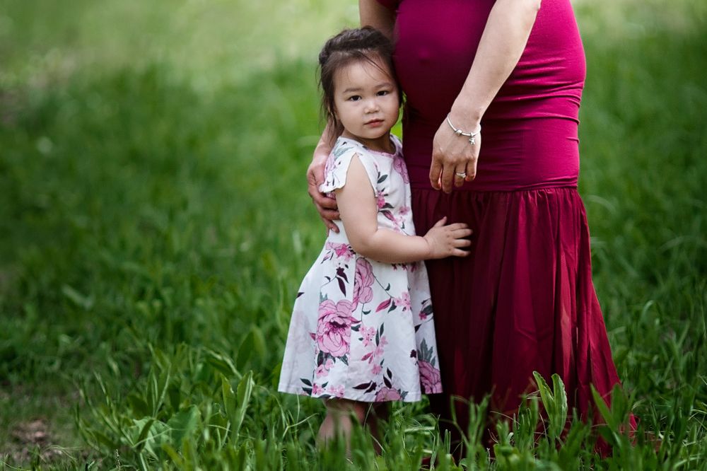 Toddler perfectly coordinated with her mama in a burgundy maternity dress.