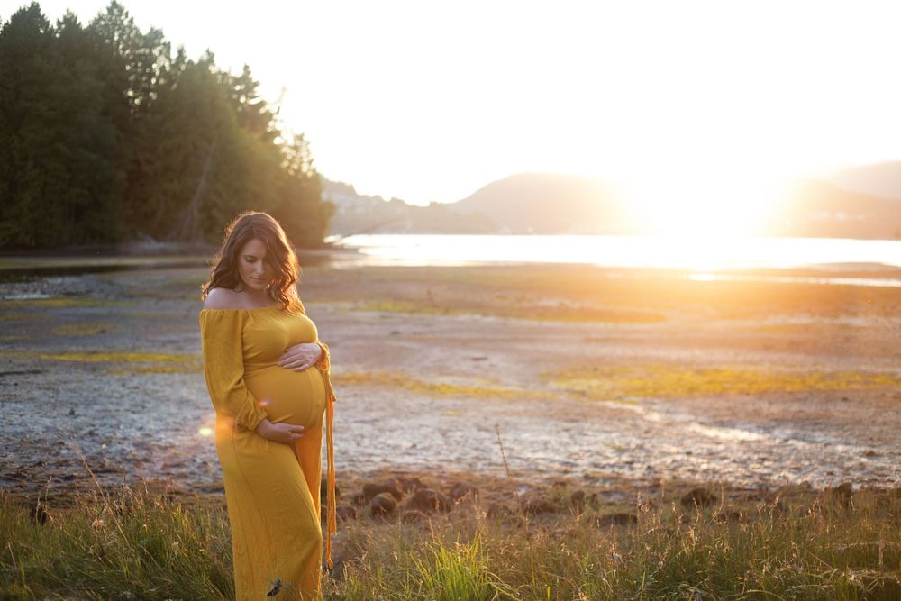 Mom to be in a yellow dress which perfectly compliments the golden hour.