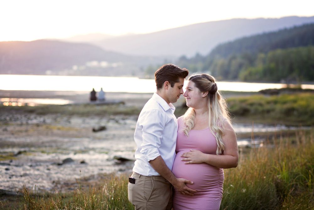 Parents to be share a cute moment together at the beach.