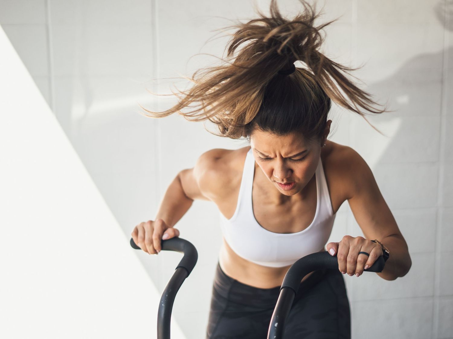 Determined athlete working out intensely on a battle rope exercise machine.