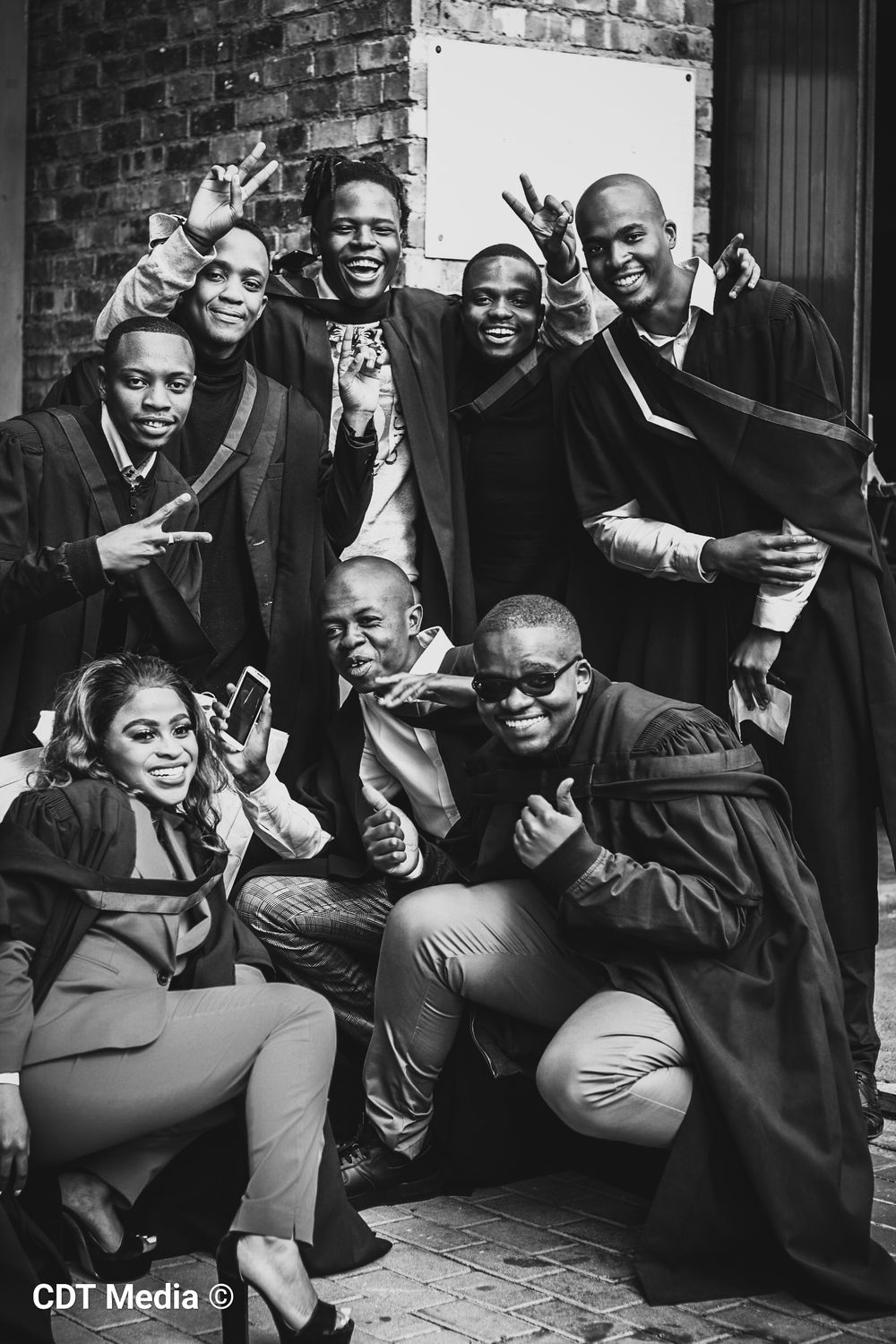 Graduation photography, graduation shoot with a degree certificate, wearing gowns and holding their degrees. Graduates group photo