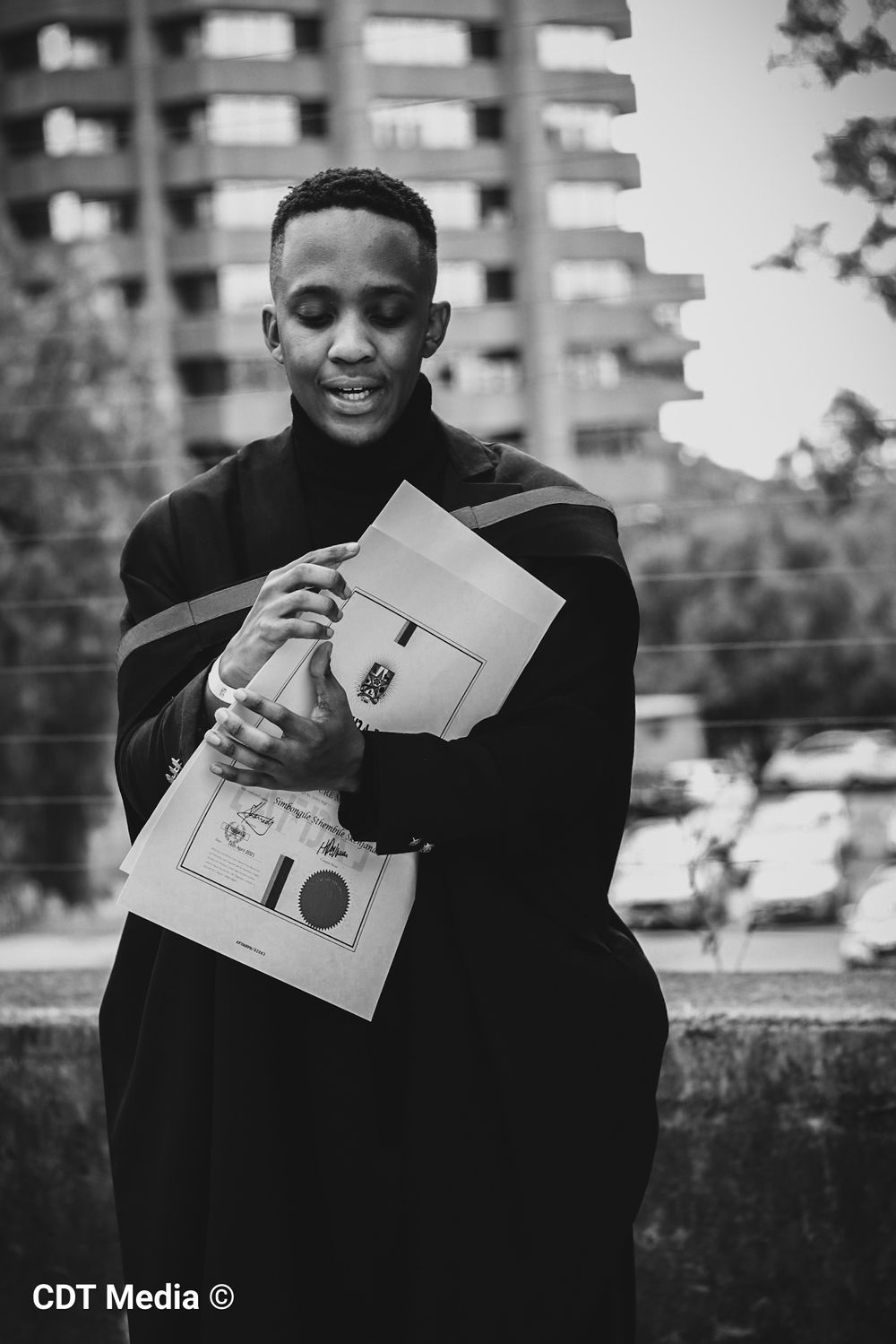 Graduation photography, graduation shoot with a degree certificate, wearing gowns and holding their degrees.