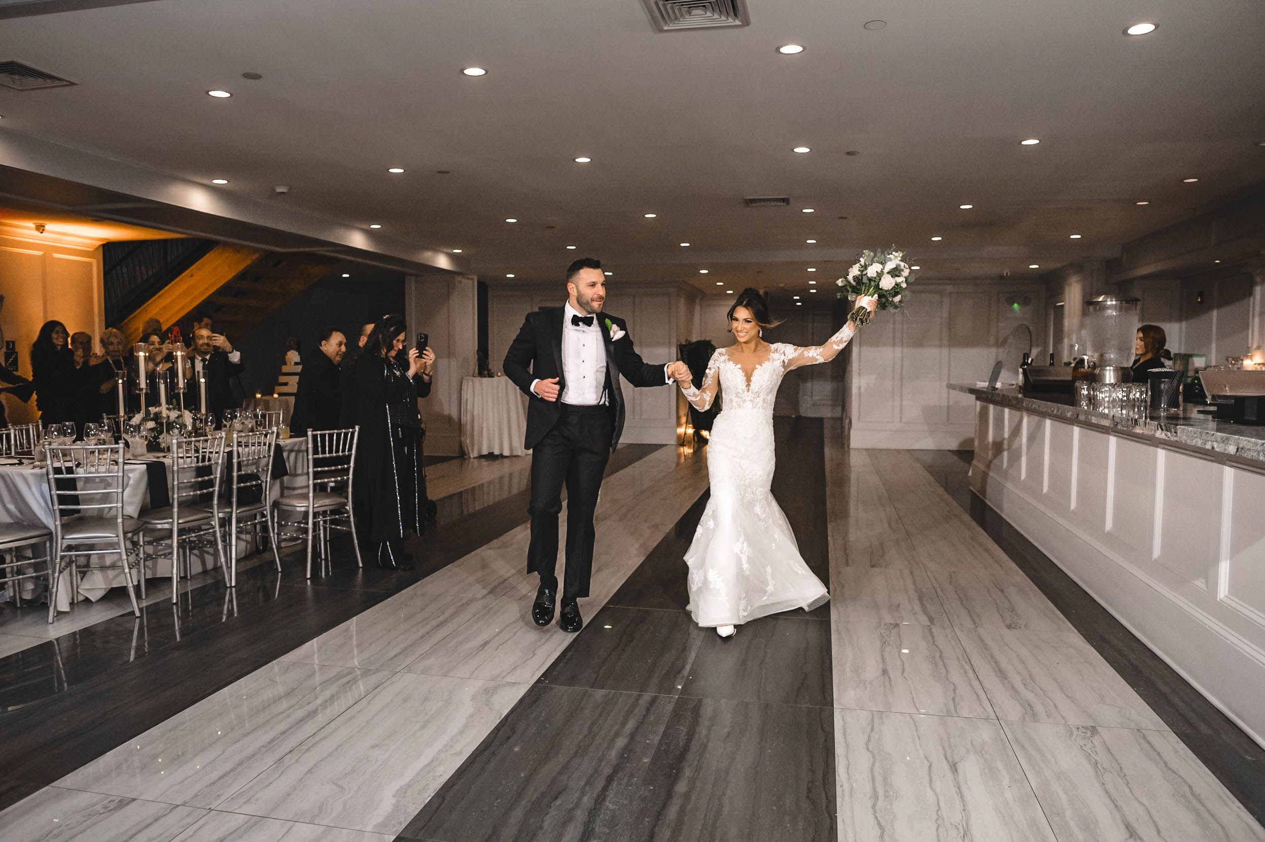 Joyful celebration in modern reception venue with grey flooring and silver decor.