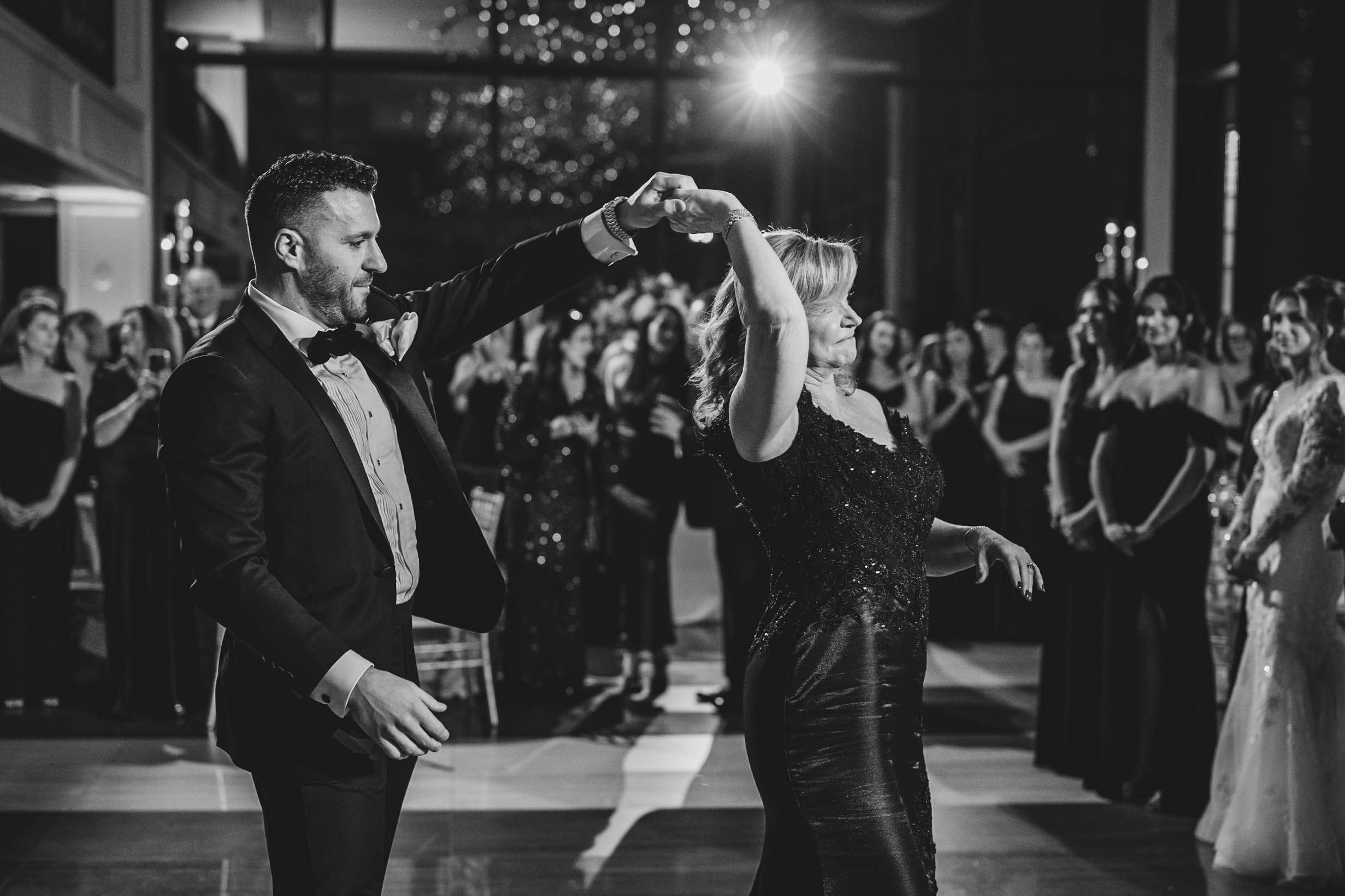 Wedding celebration in full swing with guests dancing under ambient lighting.