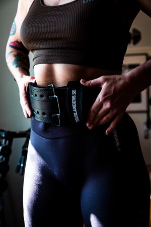 Close-up of weightlifting belt worn with workout attire.