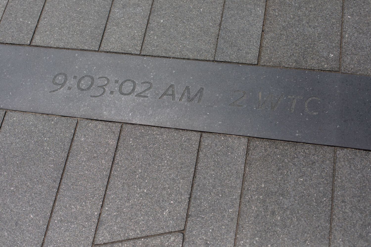 Time inscription showing 9:03:02 AM carved in memorial stone.