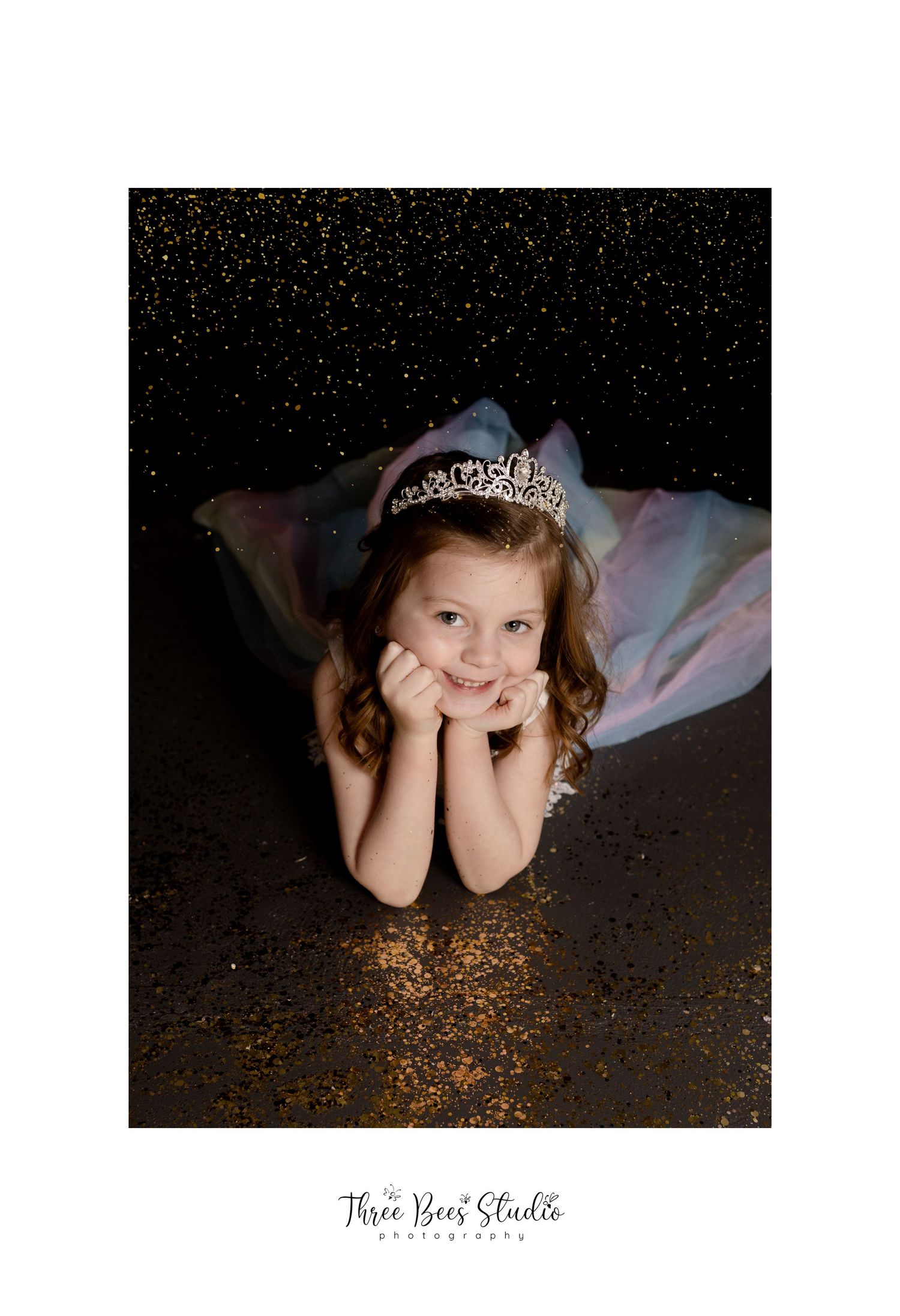 Magical portrait with sparkling glitter and tiara against dark background.
