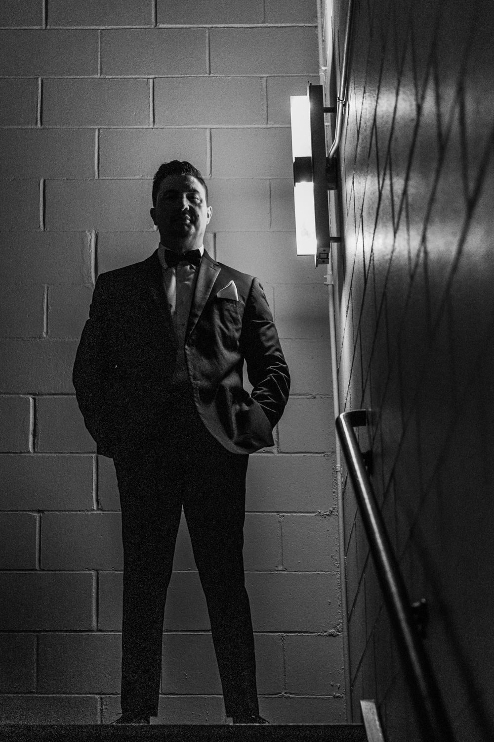 Dramatic black and white silhouette of person against concrete wall with moody lighting.