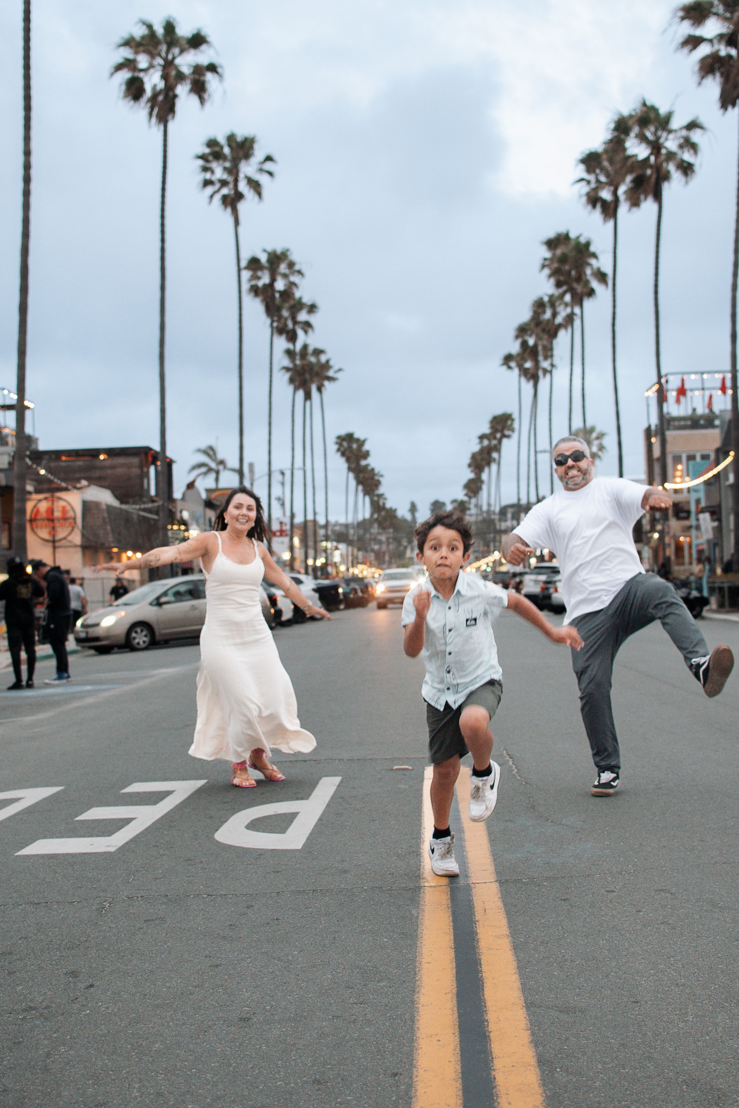 Dynamic street dance photoshoot with palm trees and urban background.