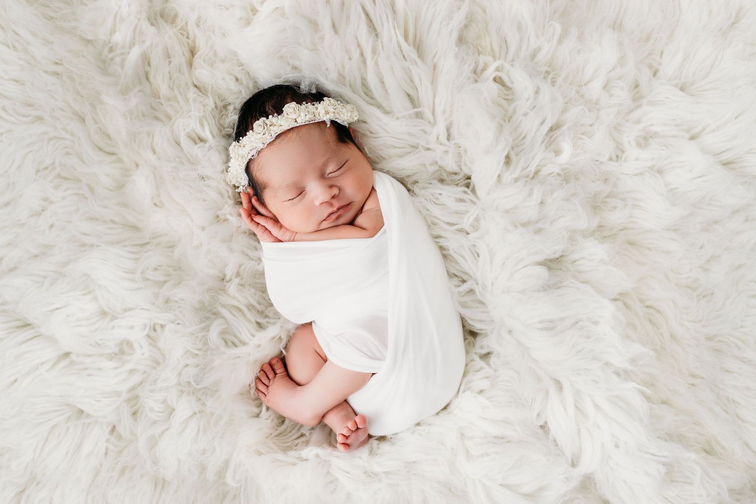 Newborn photo of baby swaddled in a fur blanket. Sweet newborn photos by Santa Fe photographer.