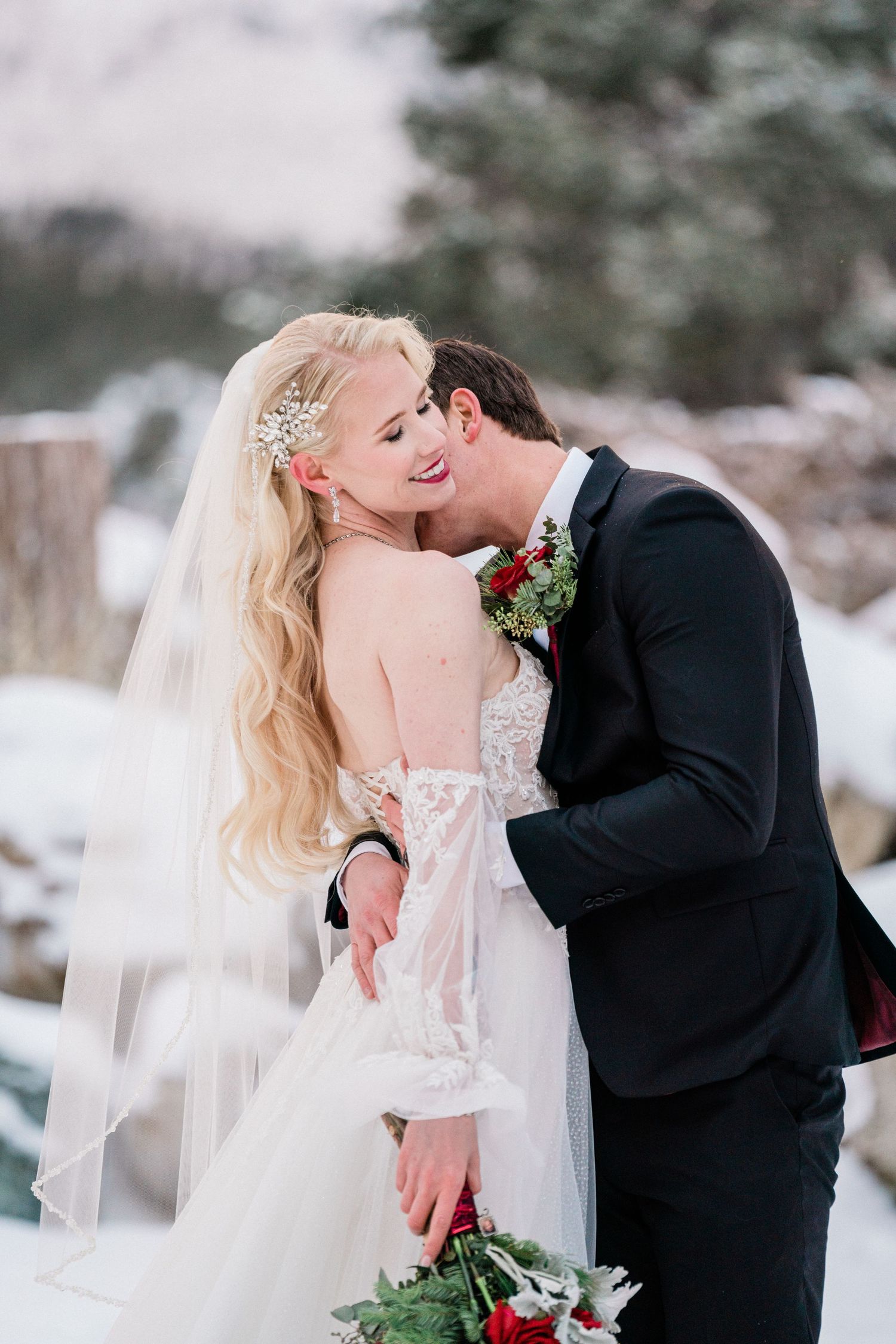 Romantic winter wedding photo of a couple sharing an intimate moment in the snow.