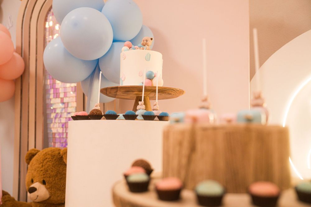 Gender reveal party decor with blue and pink balloon arrangements.