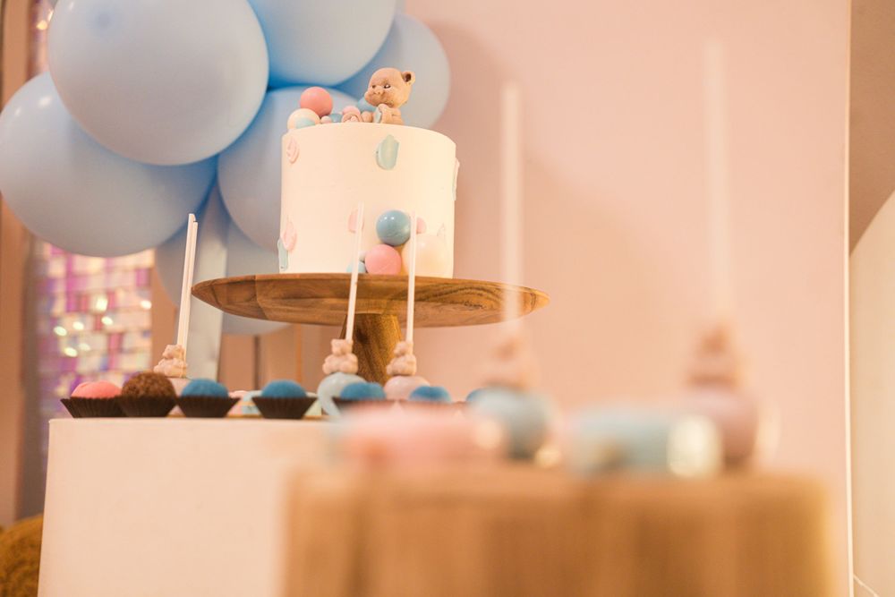 Baby celebration dessert table with pastel colored decorations and balloons.