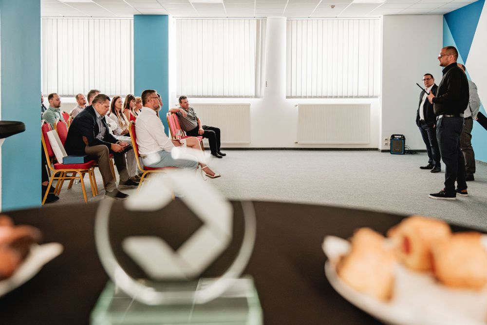 Conference room with blue walls and natural lighting during a business event.