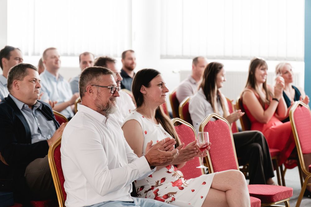 Audience members applauding during a business conference presentation.